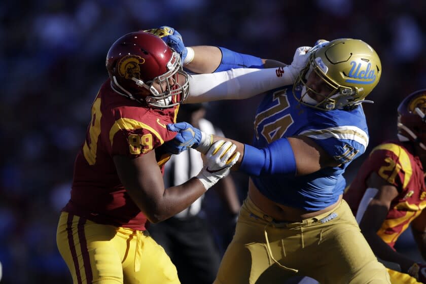 Southern California defensive lineman Christian Rector, left, works against UCLA offensive lineman Sean Rhyan (74) during the second half of an NCAA college football game Saturday, Nov. 23, 2019, in Los Angeles. (AP Photo/Marcio Jose Sanchez)