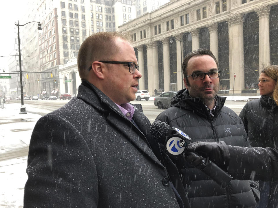 Adam Belz-Thomas, left, and husband Kyle Belz-Thomas, of Romeo, Mich., speak to reporters outside U.S. District Court in Detroit, Wednesday, Feb. 26, 2020. They were among the victims of Tara Lee, a suburban Detroit woman who was sentenced to 121 months in prison for committing fraud in arranging adoptions. (AP Photo/Ed White)
