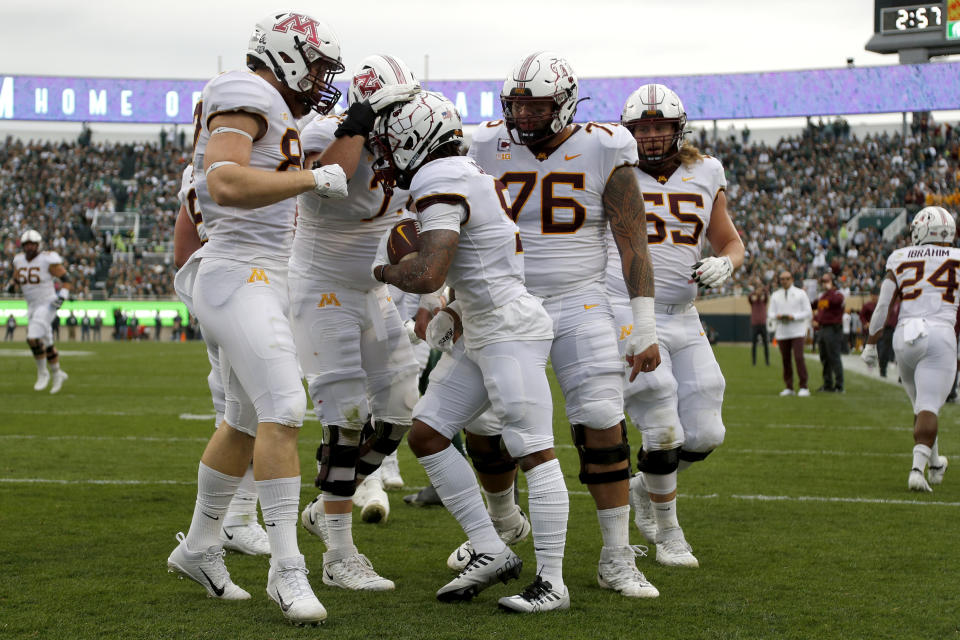 Minnesota players celebrate with Daniel Jackson, center, after his touchdown against Michigan State during the first quarter of an NCAA college football game, Saturday, Sept. 24, 2022, in East Lansing, Mich. (AP Photo/Al Goldis)