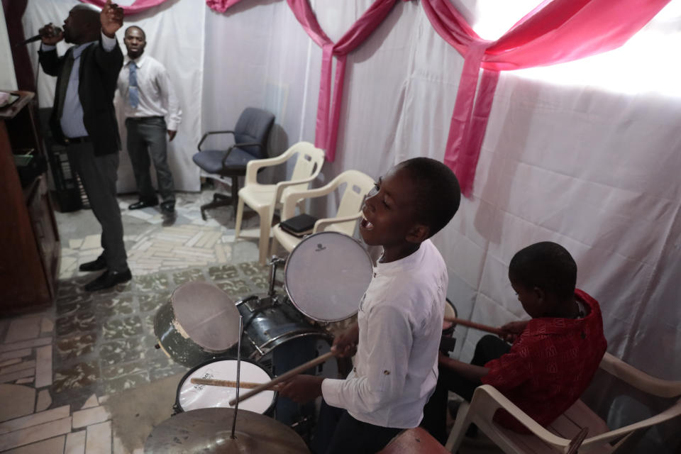 Woodberson Seide plays the drums during service at a Protestant church in Port-au-Prince, Haiti, Sunday, Sept. 24, 2023. Woodberson Seide's family sleeps on the floor of a church, something they've done since losing their home to gangs. (AP Photo/Odelyn Joseph)