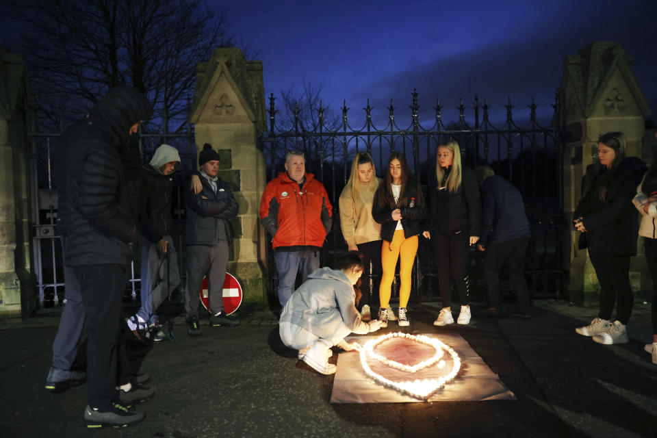 Youth from St. Peter's Immaculata Youth Centre and the Townsend Street Social Outreach Centre light candles at Belfast City cemetery for Holocaust Remembrance Day, in west Belfast, Northern Ireland, Friday, Jan. 27, 2023. Twenty-five years ago, the Good Friday Agreement halted much of the violence of Northern Ireland’s Troubles. Today, grassroots faith leaders are trying to build on that opportunity. They're working toward reconciliation in a land where religion was often part of the problem. (AP Photo/Peter Morrison)