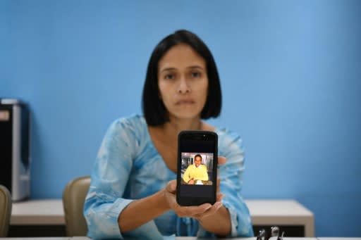 Venezuelan Mirian Gamarra, 39, displays a picture of her dead son Luis Alfredo Ariza, 21, on her mobile phone -- she says he was gunned down by special police for no reason