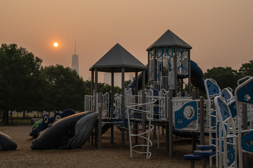 JERSEY CITY, NEW JERSEY - JUNE 8: The sun rises next the One World Trade Center in New York as a playground looks empty, while the smoke from Canada wildfires covers the Manhattan borough as it is seen from Liberty State Park on June 8, 2023 in New Jersey. (Photo by Eduardo Munoz Alvarez/Getty Images)