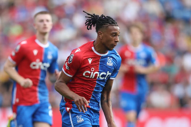 Michael Olise dribbles with the ball during a Premier League game.