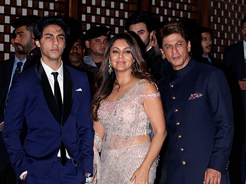 Indian Bollywood actor Shah Rukh Khan (R) poses for a picture with his wife Gauri Khan and son Aryan Khan (L).   (Getty Images)