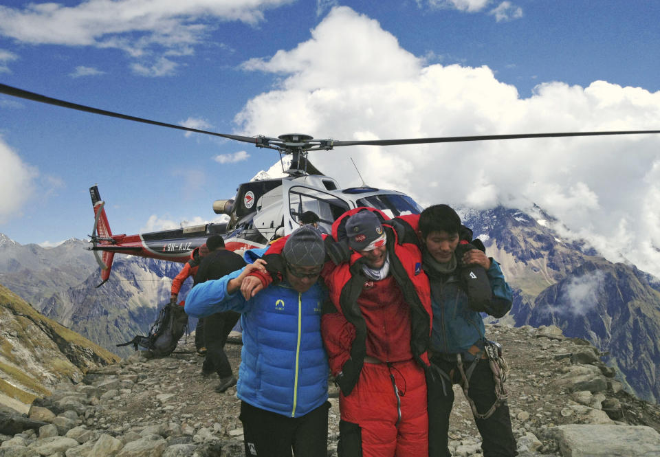 In this photo provided by Nepalese airline Simrik Air, an injured victim, center, of an avalanche is rescued at the base camp of Mount Manaslu in northern Nepal, Sunday, Sept. 23, 2012. The avalanche swept away climbers on a Himalayan peak in Nepal on Sunday, leaving at least nine dead and six others missing, officials said. (AP Photo/Simrik Air)