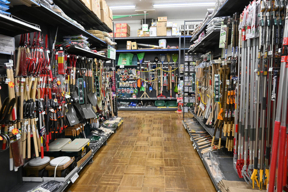Interior of a hardware store with various tools and gardening equipment displayed on shelves