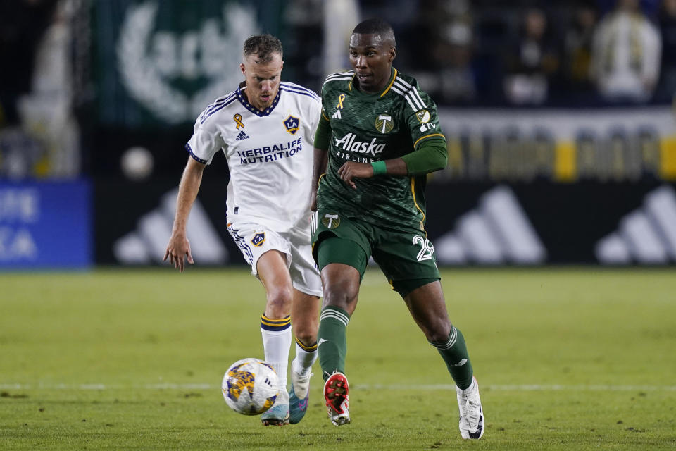 Portland Timbers defender Juan David Mosquera, right, controls the ball as LA Galaxy midfielder Oriol "Uri" Rosell chases during the second half of an MLS soccer match, Saturday, Sept. 30, 2023, in Carson, Calif. (AP Photo/Ryan Sun)