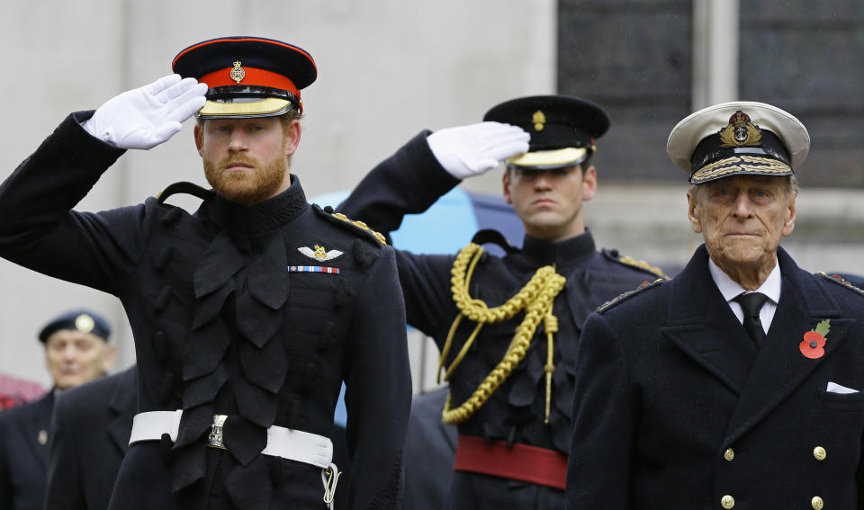 Britain's Prince Harry (L) salutes next to his grandfather Prince Philip, Duke of Edinburgh, during a visit to the Field of Remembrance at Westminster Abbey in central London on November 5, 2015. The Duke of Edinburgh and Prince Harry each placed a Cross of Remembrance for Unknown British Soldiers from the First and Second World Wars. AFP Photo/Kirsty Wigglesworth/POOL (Photo by KIRSTY WIGGLESWORTH / POOL / AFP) (Photo by KIRSTY WIGGLESWORTH/POOL/AFP via Getty Images)