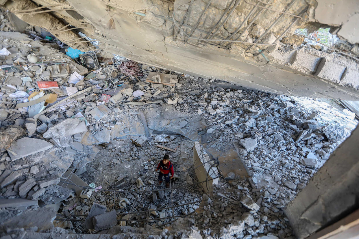  A young boy looks at damage to a building following Israeli airstrikes in Rafah, Gaza, today. The U.S. has sought to avoid the war spreading. (Ahmad Hasaballah / Getty Images)