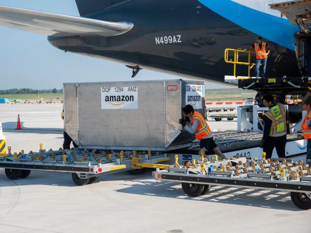 Amazon employees load cargo onto Amazon Air plane at new cargo hub