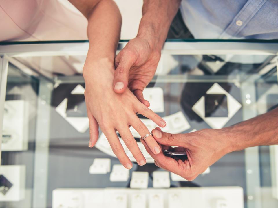 Cropped image of couple choosing wedding ring in the shopping mall.