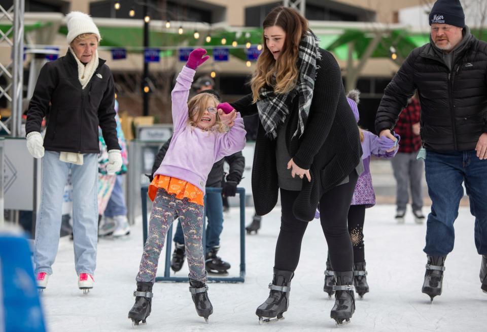 Kinley Gleason, left, loses her balance on the ice as she holds her mom Jamie Gleason's hand during the Winter Blast Royal Oak on Saturday, Feb. 3, 2024.