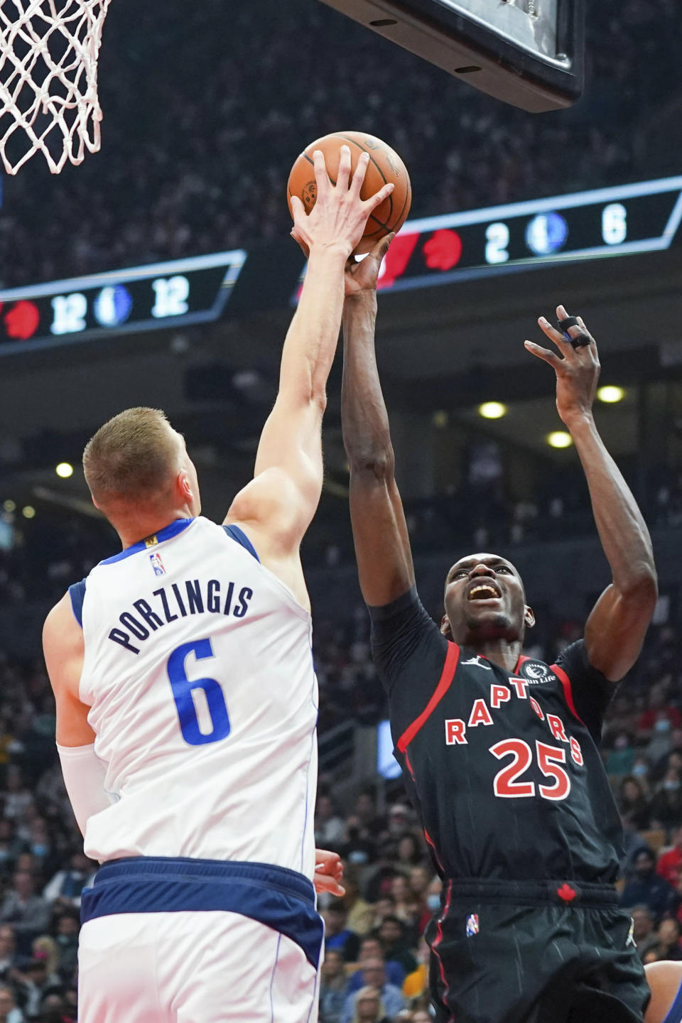 Dallas Mavericks centre Kristaps Porzingis (6) blocks a shot by Toronto Raptors forward Chris Boucher (25) during the first half of an NBA basketball game Saturday, Oct. 23, 2021, in Toronto. (Evan Buhler/The Canadian Press via AP)