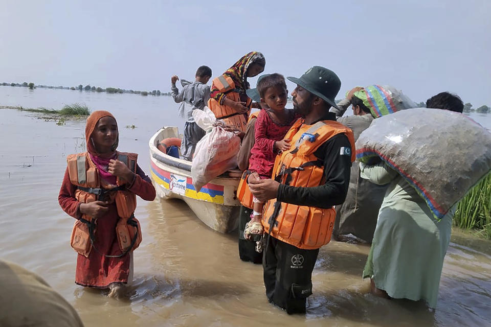 In this photo released by Rescue 1122 Emergency Department, rescue workers evacuate villagers through a boat from a flooded area of Bahawalnagar district in Pakistan's Punjab province, Wednesday, Aug. 23, 2023. Rescuers have evacuated more than 100,000 people from flood-hit areas of Pakistan's eastern Punjab province in the past three weeks, officials said Wednesday. (Rescue 1122 Emergency Department vis AP)