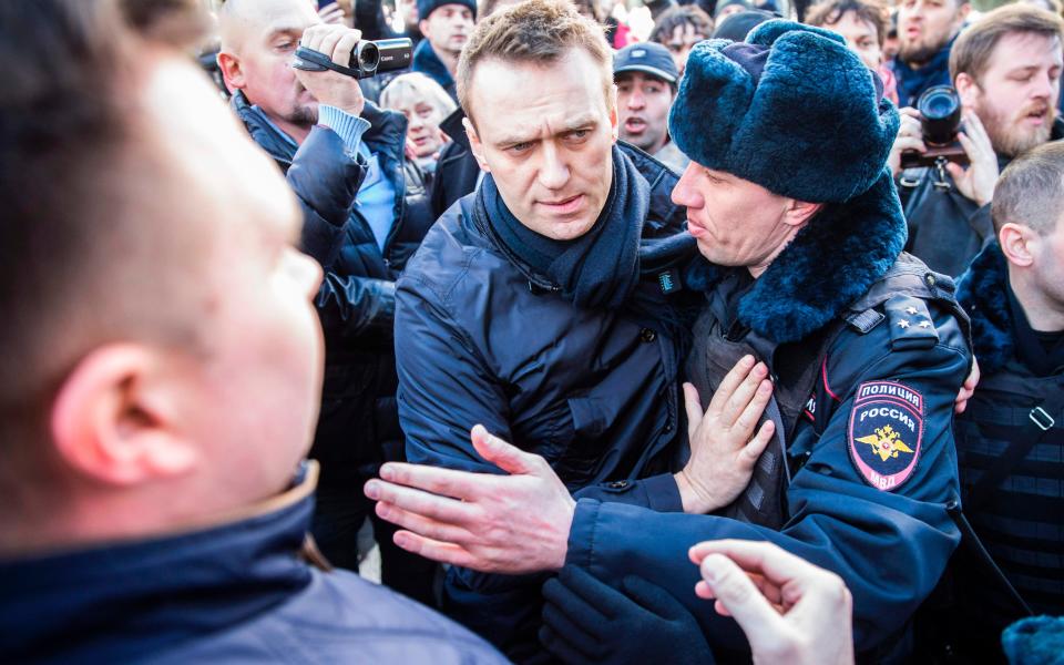 Police officers detain Kremlin critic Alexei Navalny during an unauthorised anti-corruption rally in central Moscow - Credit: AFP/Getty Images