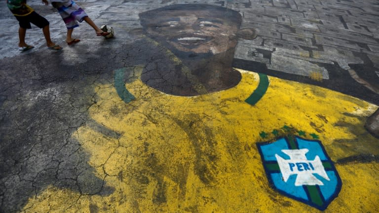 Children play football on a street painted with the image of Brazilian football player Gabriel Jesus in the neighborhood where he grew up in Sao Paulo, Brazil