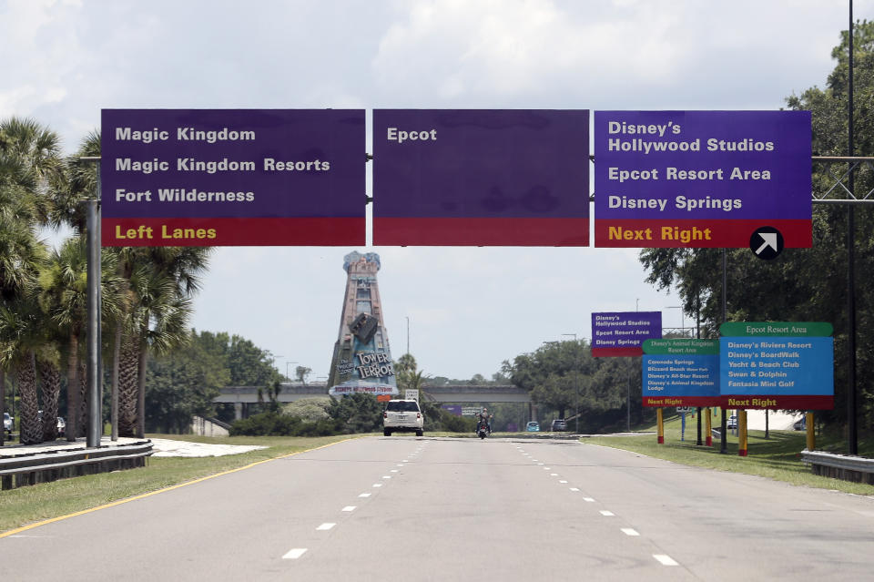 Signs direct motorists to the various theme parks at Walt Disney World, Thursday, July 2, 2020, in Lake Buena Vista, Fla. Magic Kingdom and Animal Kingdom will reopen on July 11. Disney World's other two parks, Epcot and Disney's Hollywood Studios, will welcome back guests four days later. (AP Photo/John Raoux)