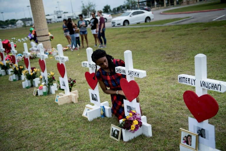 Jai Gillard, a freshman who was in the class where the mass shooting started, looks at a cross for Sabika Sheikh before signing it at a memorial for the victims of the Santa Fe High School shooting on May 21, 2018