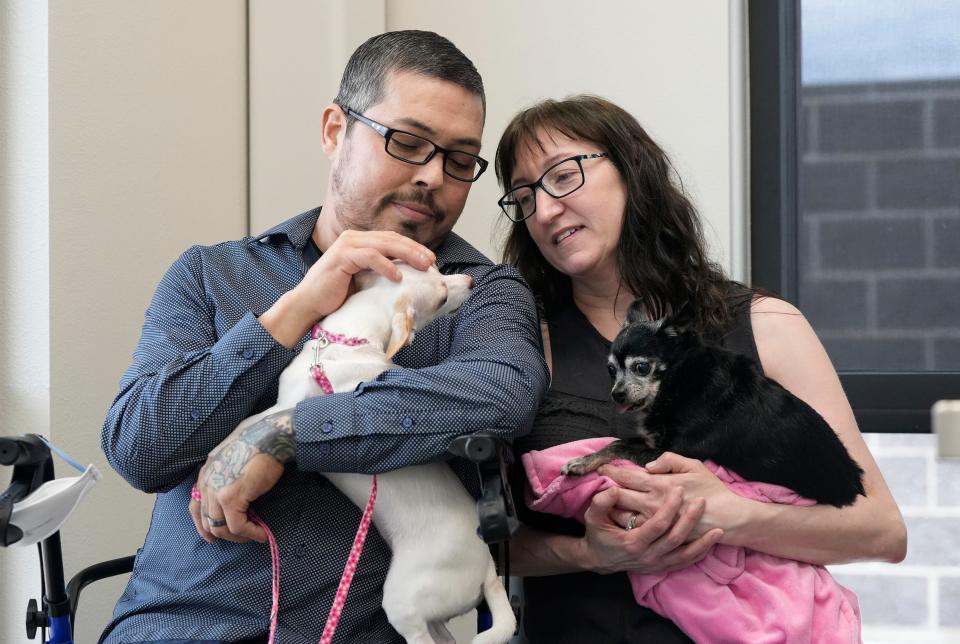 Charles and Nicole Richard hold their Chihuahuas, Chulita and Chili, at Firehouse Animal Health Center in Kyle on Tuesday. "I'm so glad this was an option to explore," Charles said. "It's a lot of money, and we definitely couldn't have afforded it at all."