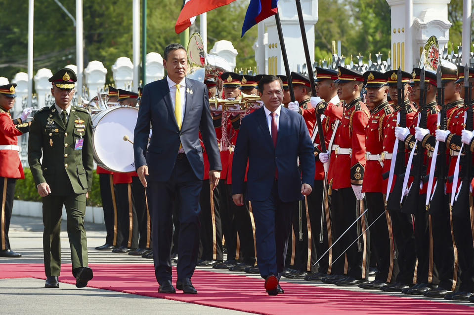 In this photo released by the government spokesman office, Thailand's Prime Minister Srettha Thavisin, center left, and Cambodia's Prime Minister Hun Manet, center right, review an honor guard during a welcoming ceremony at the Government House in Bangkok, Thailand, Wednesday, Feb. 7, 2024. (Government Spokesman Office via AP)