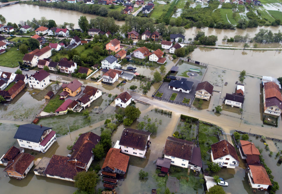 This aerial photo shows flooded neighborhood in Sanski Most, Bosnia-Herzegovina, Tuesday, May 14, 2019. Homes and roads have been flooded in parts of Bosnia after rivers broke their banks following heavy rains, triggering concerns Tuesday of a repeat of floods five years ago when dozens died. (AP Photo/Darko Bandic)