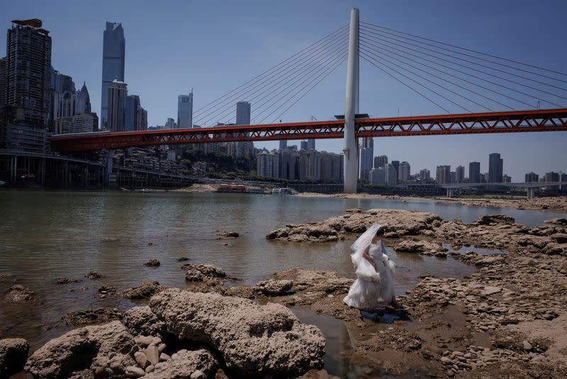 FOTO DE ARCHIVO. Una mujer vestida de novia camina por el lecho seco del río Jialing, un afluente del Yangtsé, que se acerca a niveles de agua mínimos en Chongqing, China