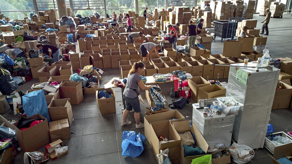 Volunteers sort donations at the donation centre on the Ring Boulevard of Nurburg, Germany, before they are delivered to the flood disaster area, Thursday July 22, 2021. In the flood disaster area of Erftstadt-Blessem, some residents are being allowed back into their homes to clear debris after heavy rains caused devastating floods. (Thomas Frey/dpa via AP)