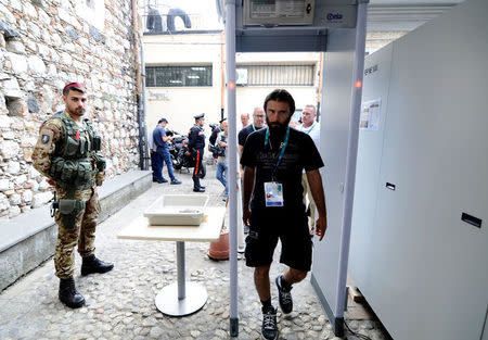 An Italian Army soldier patrols as a man walks through a metal detector in Taormina where leaders from the world's major Western powers will hold their annual summit, Italy, May 24, 2017. REUTERS/Guglielmo Mangiapane