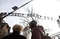 Jona Laks, survivor of Dr. Josef Mengele's twins experimentsand her granddaughter, Lee Aldar stand next to the gate with the slogan "Arbeit macht frei" ("Work sets you free") as they start their visit at the Auschwitz death camp in Oswiecim