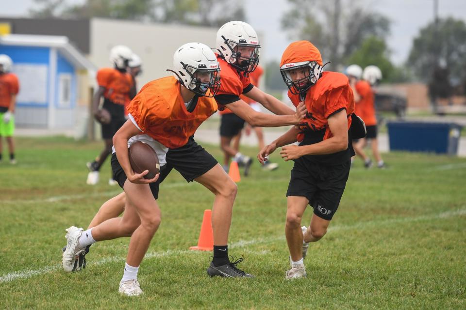 Lennox football player tries to dodge other players at Lennox High School in Lennox, South Dakota on Monday, August 21, 2023.