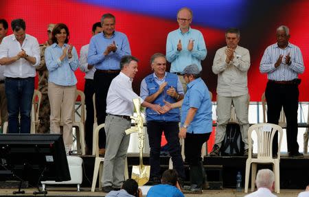 Colombia's Marxist FARC rebel leader Rodrigo Londono, also known as Timochenko, Colombian president Juan Manuel Santos and Jean Arnault, the UN Secretary-General's Special Representative for Colombia and Head of the UN Mission to Colombia, attend the final act of abandonment of arms in Mesetas, Colombia June 27, 2017. REUTERS/Jaime Saldarriaga