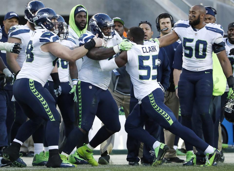 Frank Clark isn't shy in getting physical with teammates, evidenced in this shoving match he got into with teammate Jarran Reed during a game last season against the 49ers. (AP) 