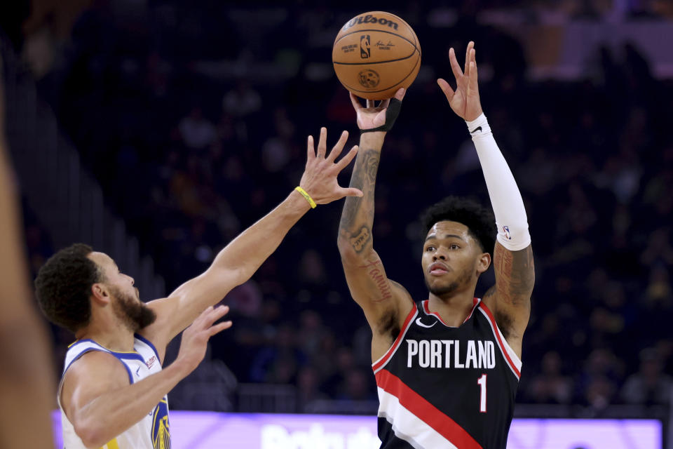 Portland Trail Blazers guard Anfernee Simons (1) shoots against Golden State Warriors guard Stephen Curry during the first half of an NBA basketball game in San Francisco, Wednesday, Dec. 6, 2023. (AP Photo/Jed Jacobsohn)