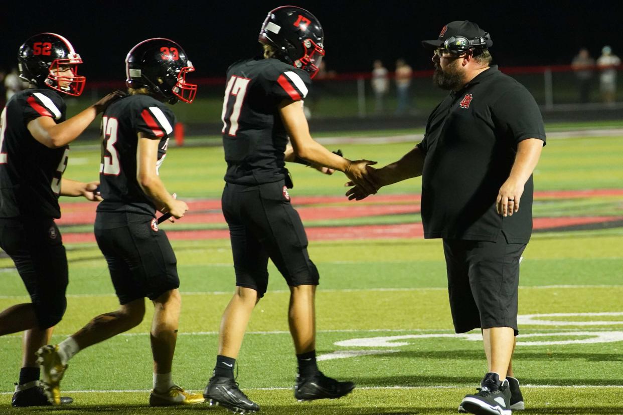 Marion Harding head football coach Dan Arndt shakes the hands of special teams players during Friday's home opener with Mount Vernon.