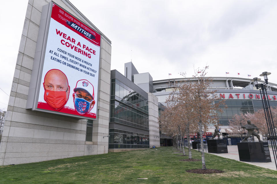 An electronic sign encouraging mask wearing is seen at Nationals Stadium, after the opening day baseball game between the Washington Nationals and New York Mets was postponed because of coronavirus concerns, Thursday, April 1, 2021, in Washington. The entire season-opening three-game series between the Washington Nationals and New York Mets was called off on Friday after three players for the 2019 World Series champions tested positive for COVID-19.(AP Photo/Jacquelyn Martin)