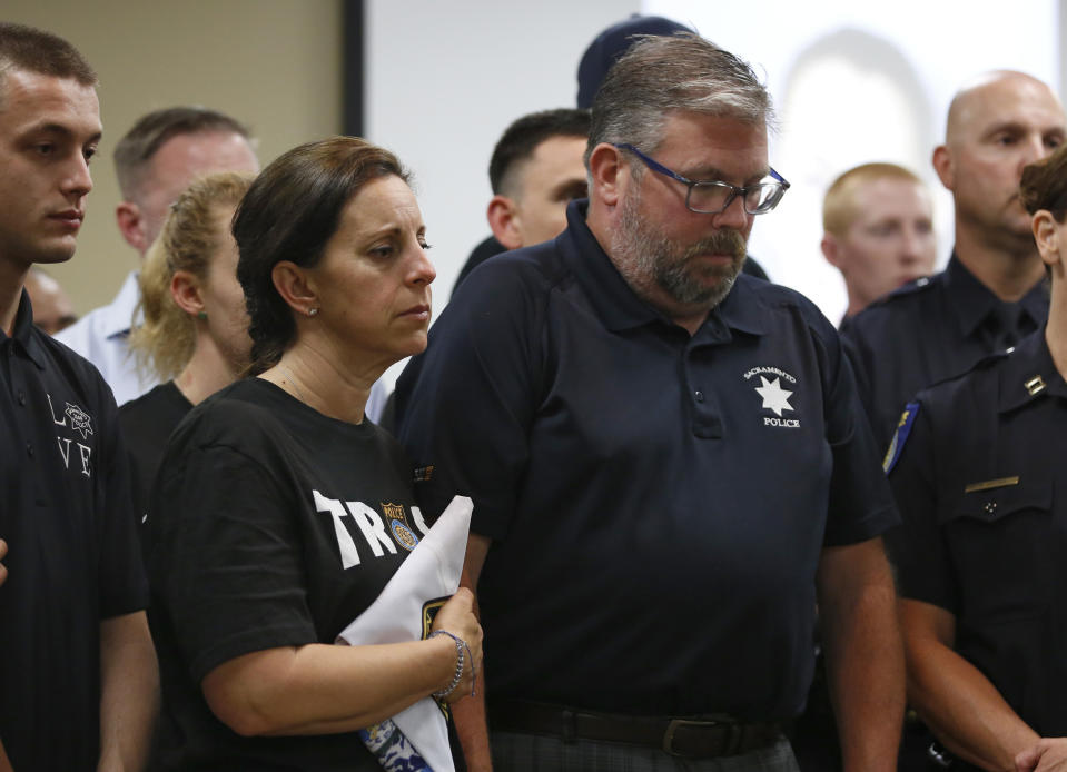 CORRECTS FIRST NAME TO KELLEY, NOT KELLY - Kelley and Denis O'Sullivan, the parents of slain Sacramento Police officer Tara O'Sullivan, hold hands during a news conference in Sacramento, Calif., Tuesday, June 25, 2019. Denis O'Sullivan told reporters that any notion that the Sacramento Police Department was responsible for her death was extremely offensive and hurtful. It took rescuers 45 minutes to reach Tara O'Sullivan after she was shot by gunman, who kept shooting at police, during a domestic violence call last week. (AP Photo/Rich Pedroncelli)