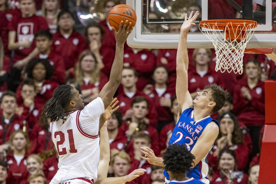 Indiana forward Mackenzie Mgbako (21) shoots while being defended by Kansas forward Parker Braun (23) during the first half of an NCAA college basketball game, Saturday, Dec. 16, 2023, in Bloomington, Ind. (AP Photo/Doug McSchooler)