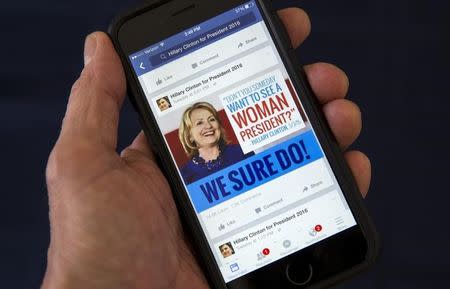 A mobile phone shows a Facebook page of campaign propaganda to promote Hillary Clinton as president in 2016, in this photo illustration taken April 13, 2015. REUTERS/Mike Segar