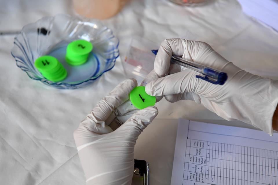 A staff member of the Rajawadi Hospital holds the first token to be given to a health worker to receive the Covid-19 coronavirus vaccine in Mumbai on January 16, 2021. (Photo by Indranil MUKHERJEE / AFP) (Photo by INDRANIL MUKHERJEE/AFP via Getty Images)