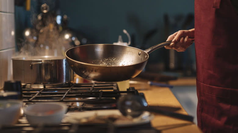 person holding a wok