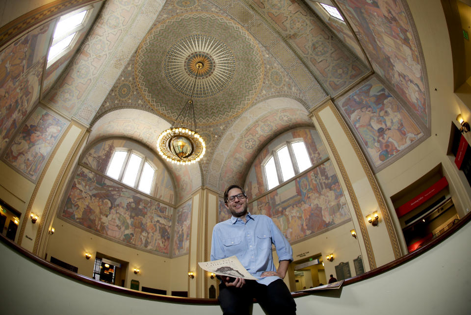 Josh Kun, the curator who organized a collection of music themed around Loa Angeles poses for a picture at the main branch of the Los Angeles Public Library Friday, June 21, 2013 in Los Angeles. Kun, a USC professor and some of his students, have digitized them, put a cross-section of nearly 200 into a colorful coffee-table book and even persuaded the LA fusion group Ozomatli to perform many at a concert later this summer. (AP Photo/Chris Carlson)