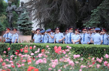 Law enforcement officers stand guard during a rally held by opposition supporters in Almaty