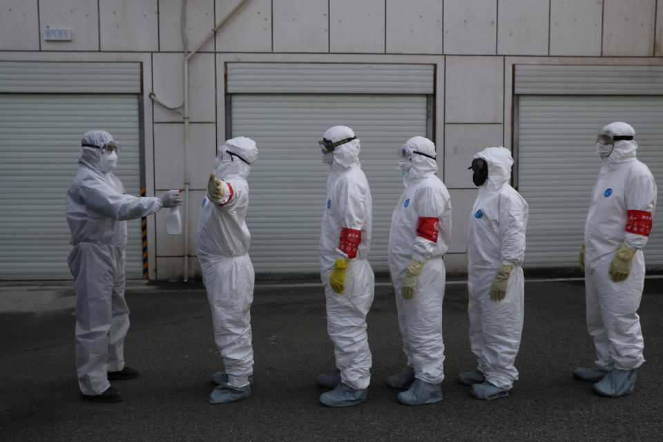 Volunteers in protective suits are being disinfected in a line in Wuhan, the epicentre of the novel coronavirus outbreak, in Hubei province, China February 22, 2020. Source: China Daily/Reuters