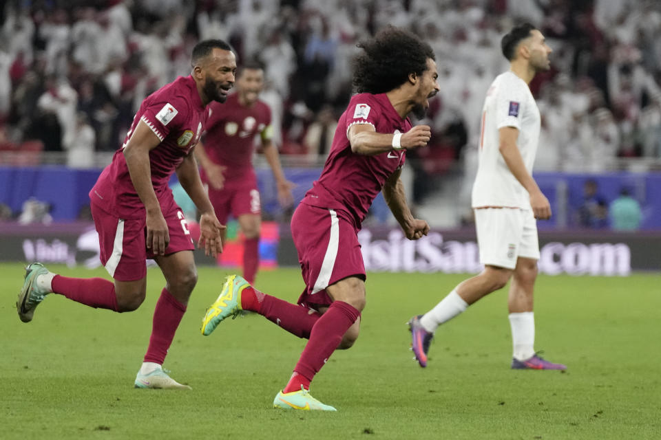 Qatar's Akram Afif, centre, celebrates after scoring his side's second goal during the Asian Cup semifinal soccer match between Iran and Qatar at Al Thumama Stadium in Doha, Qatar, Wednesday, Feb. 7, 2024. (AP Photo/Aijaz Rahi)