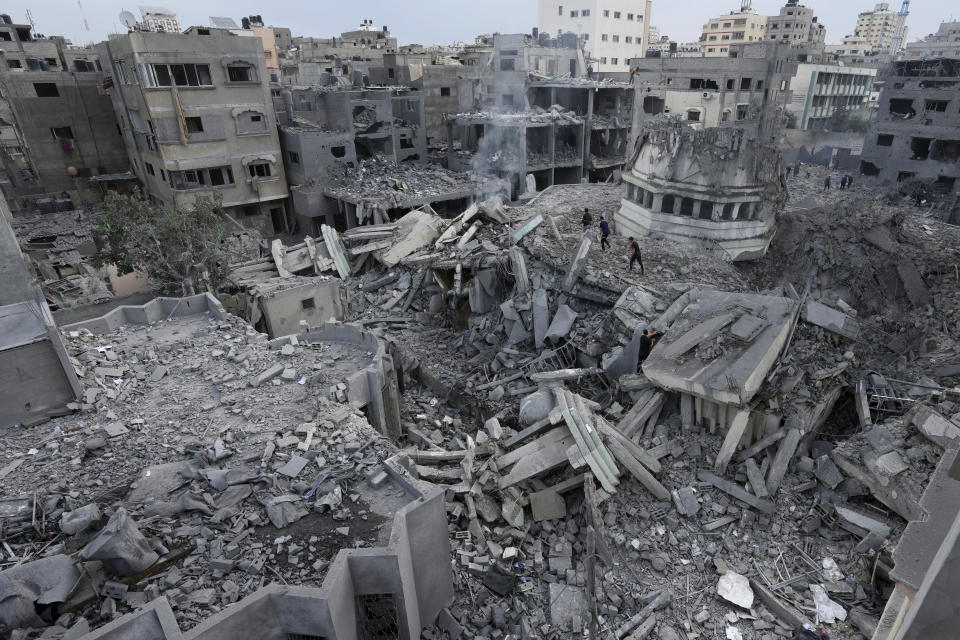 Palestinians inspect the rubble of the Yassin Mosque destroyed after it was hit by an Israeli airstrike at Shati refugee camp in Gaza City, early Monday, Oct. 9, 2023. Israel's military battled to drive Hamas fighters out of southern towns and seal its borders Monday as it pounded the Gaza Strip. (AP Photo/Adel Hana)