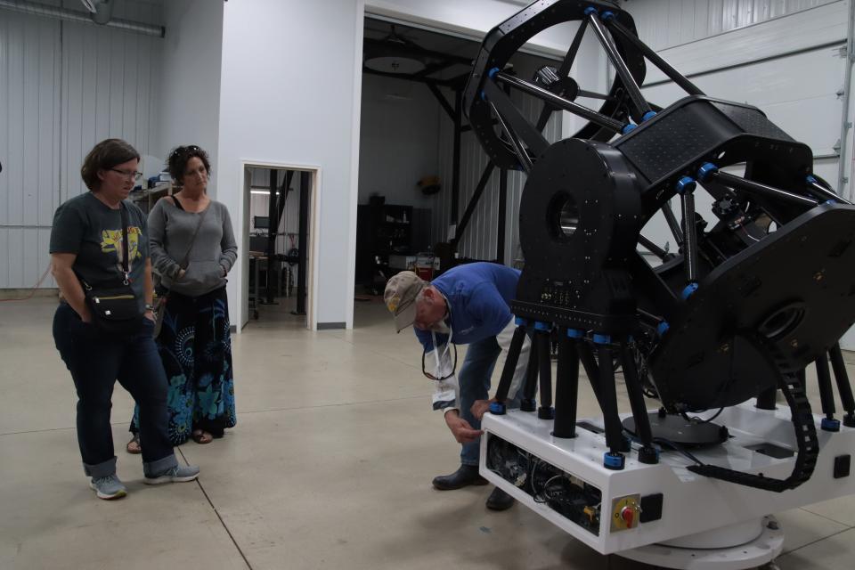 Jessica Swanger and Sandy Fults, both of Tecumseh, listen as Dave Pasley, a mechanical engineer at PlaneWave Instruments, describes one of the company's telescopes Sunday, Oct. 2, 2022, during the company's open house and science expo at its headquarters in Adrian.