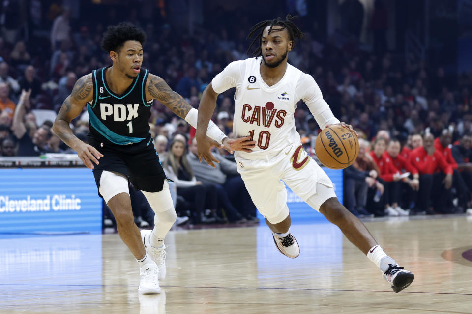 Cleveland Cavaliers guard Darius Garland (10) drives against Portland Trail Blazers guard Anfernee Simons (1) during the first half of an NBA basketball game, Wednesday, Nov. 23, 2022, in Cleveland. (AP Photo/Ron Schwane)