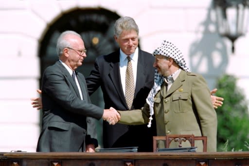 Then US President Bill Clinton (C) stands between PLO leader Yasser Arafat (R) and Israeli Prime Minister Yitzhak Rabin (L) as they shake hands on September 13, 1993 at the White House after signing the Oslo Accords