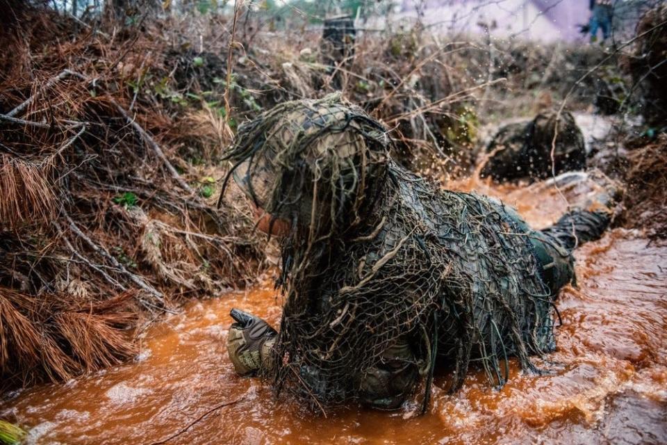 Au cours de la troisième semaine de l'école des tireurs d'élite de l'armée américaine, 35 élèves participent au lavage ghillie, conçu pour tester la résistance et la durabilité des combinaisons ainsi que pour les résister aux intempéries.